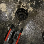Drain being snaked with electric drain snaking machine