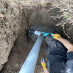 Technician installing a drain line at a Toronto home
